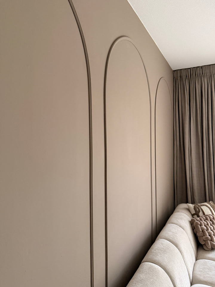 Detailopname van Velida flexlijsten op de muur, waarbij het reliëf en de strakke afwerking van de boogvorm goed zichtbaar zijn.